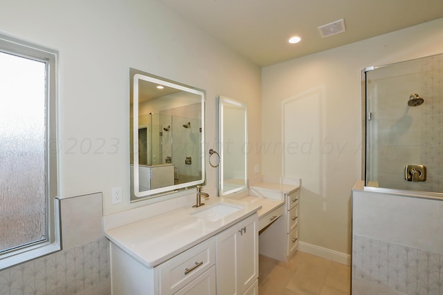 bathroom featuring tile patterned flooring, vanity, and tiled shower