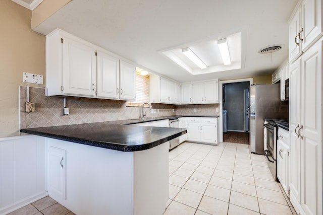 6308 Dartmouth St, Amarillo, TX 79109 - kitchen featuring appliances with stainless steel finishes, a peninsula, light tile patterned flooring, and backsplash