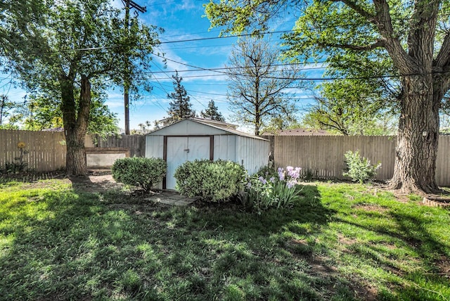 view of yard with a storage unit, a fenced backyard, and an outbuilding