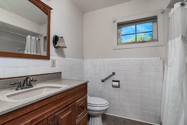 bathroom with wainscoting, tile walls, a shower with shower curtain, toilet, and vanity