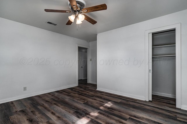 unfurnished bedroom featuring dark wood-style floors, visible vents, and baseboards