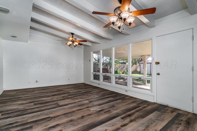 spare room featuring visible vents, baseboards, wood finished floors, a ceiling fan, and vaulted ceiling with beams