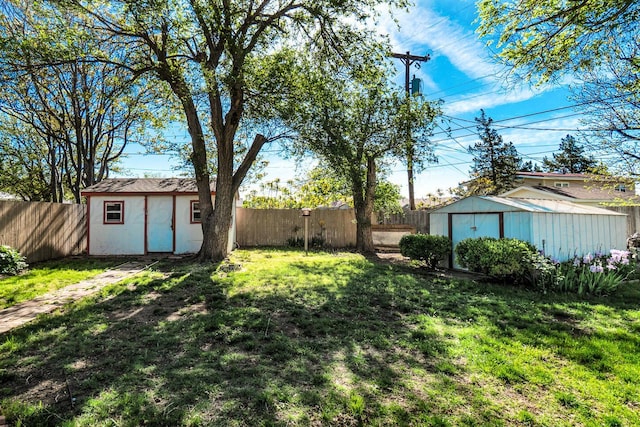 view of yard with an outbuilding, a shed, and a fenced backyard