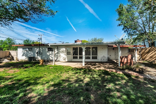 back of property featuring a chimney, a patio area, a lawn, central air condition unit, and fence