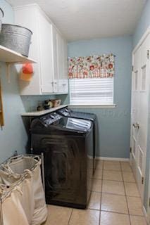 110 Dallam Ave, Dumas, TX 79029 - laundry area featuring cabinet space, washer and clothes dryer, light tile patterned floors, and baseboards