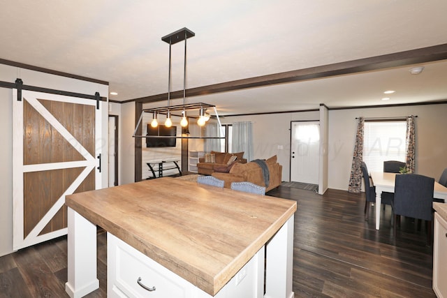 707 Trice St, Claude, TX 79019 - kitchen with ornamental molding, open floor plan, white cabinets, dark wood-type flooring, and a barn door