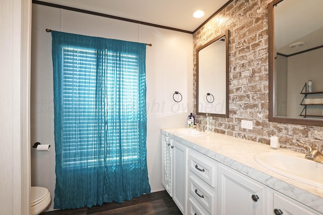 707 Trice St, Claude, TX 79019 - full bathroom featuring toilet, wood finished floors, double vanity, and a sink
