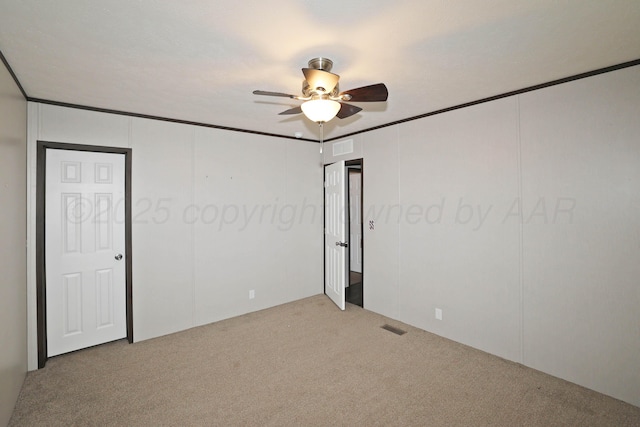 707 Trice St, Claude, TX 79019 - empty room with ornamental molding, visible vents, a ceiling fan, and carpet