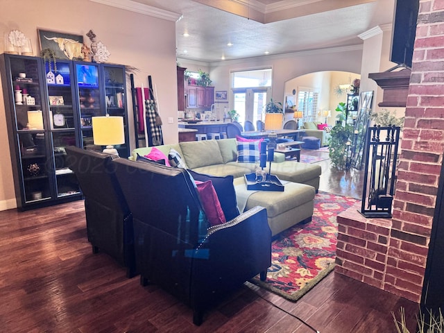 living room with crown molding, a brick fireplace, and hardwood / wood-style flooring