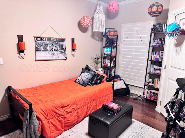 bedroom with crown molding and hardwood / wood-style flooring