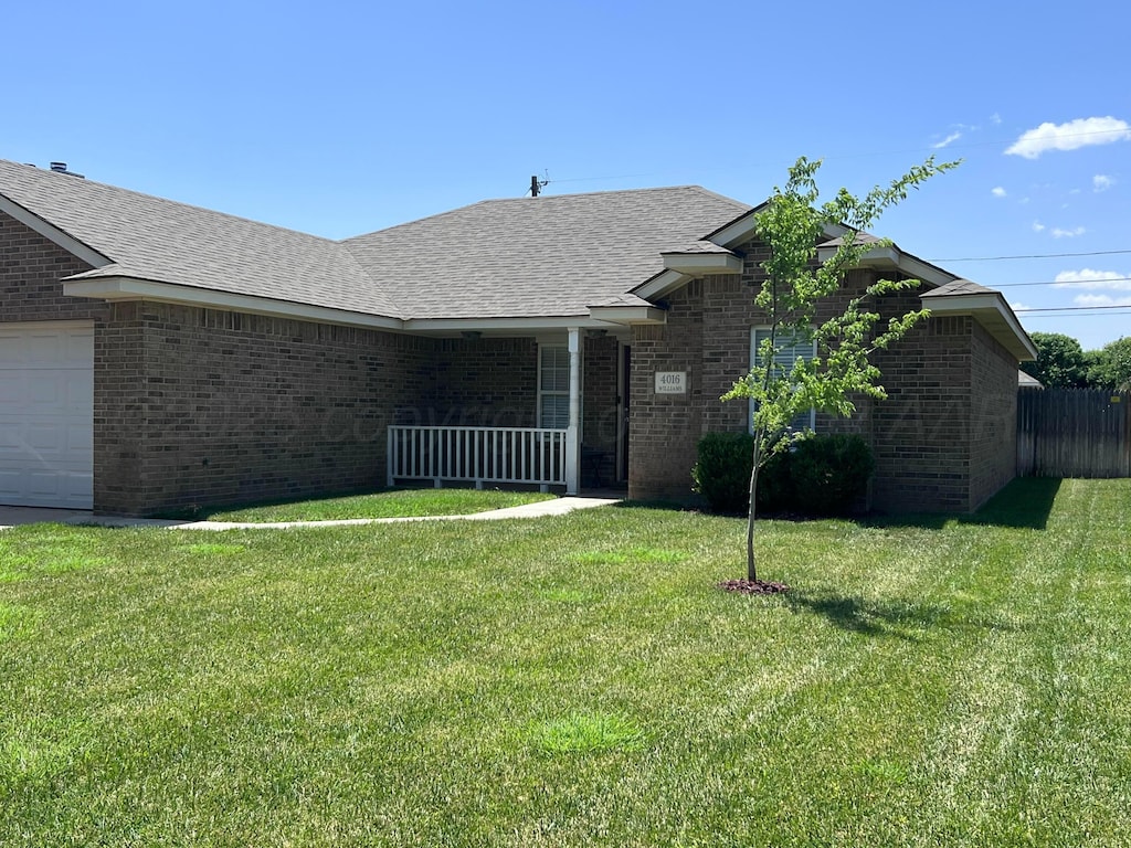 4016 S Williams St, Amarillo, TX 79118 - view of front of home with brick siding, a front lawn, an attached garage, and a shingled roof