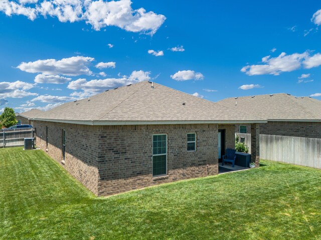 5013 Gloster St, Amarillo, TX 79118 - back of house with brick siding, a fenced backyard, a shingled roof, and a patio