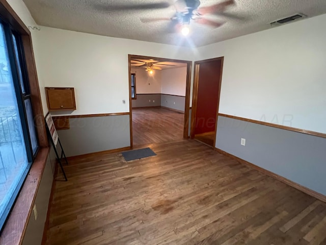 unfurnished room with hardwood / wood-style flooring, ceiling fan, and a textured ceiling