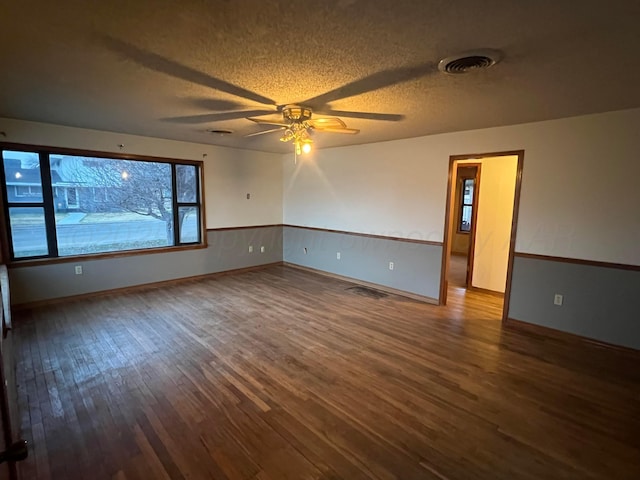 spare room with ceiling fan, wood-type flooring, and a textured ceiling