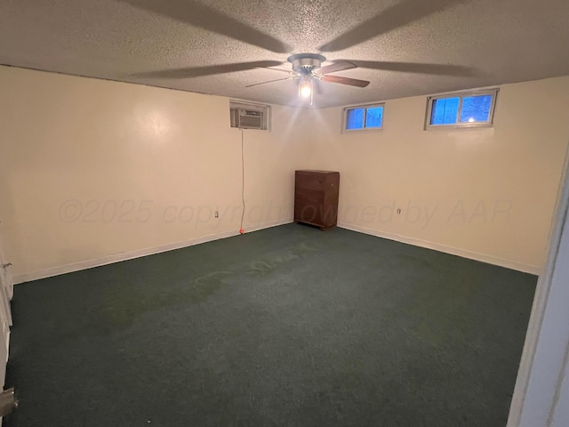 basement with ceiling fan, dark carpet, a textured ceiling, and a wall unit AC