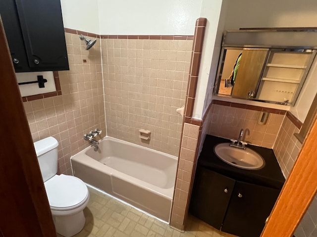 full bathroom featuring tile walls, vanity, bathtub / shower combination, and toilet