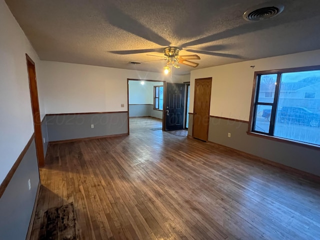 spare room featuring ceiling fan, wood-type flooring, and a textured ceiling