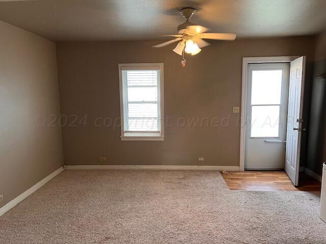 carpeted spare room featuring ceiling fan