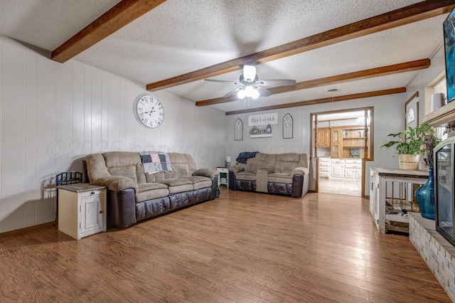 3409 Harmony St, Amarillo, TX 79109 - living room with wood finished floors, a ceiling fan, a textured ceiling, and beam ceiling
