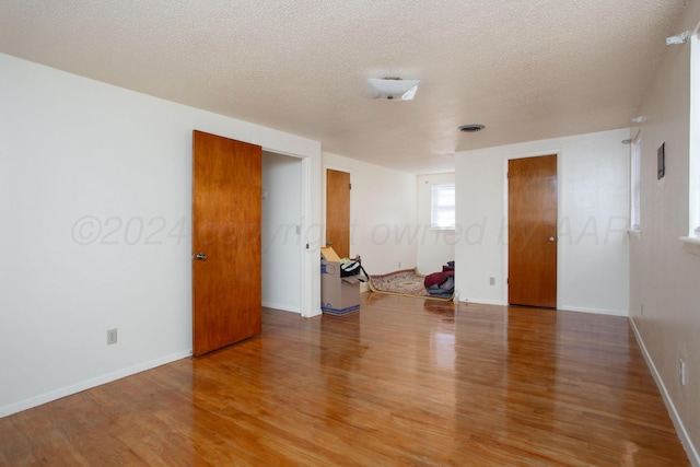 spare room featuring wood-type flooring and a textured ceiling