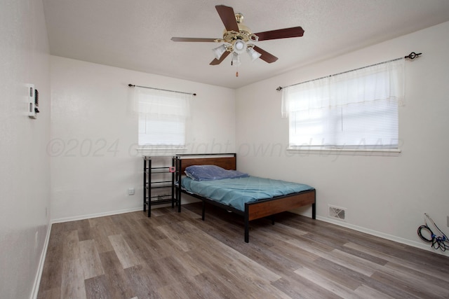 bedroom featuring a textured ceiling, light hardwood / wood-style flooring, and ceiling fan