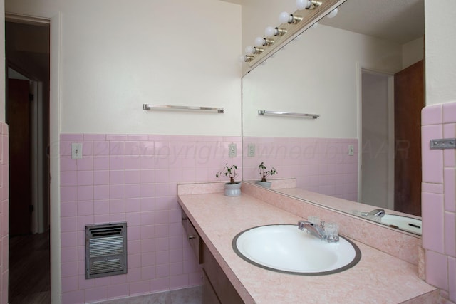 bathroom featuring vanity, heating unit, and tile walls