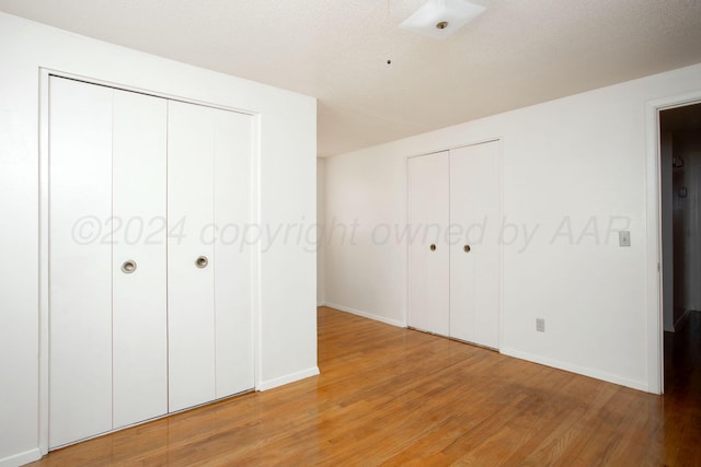 unfurnished bedroom featuring a textured ceiling and light hardwood / wood-style flooring