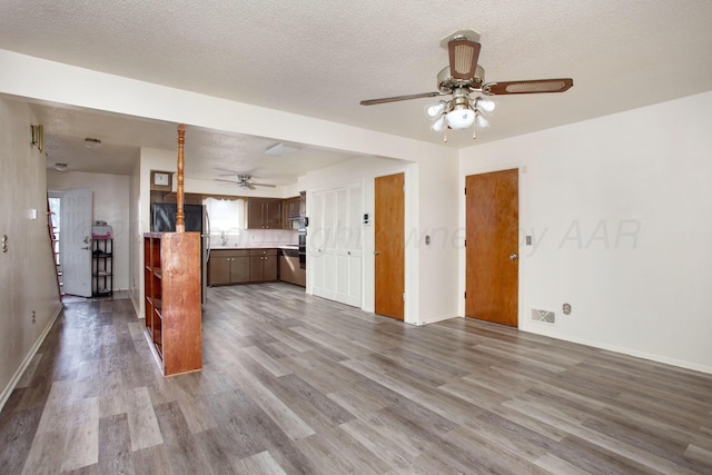 interior space with a textured ceiling, hardwood / wood-style flooring, and ceiling fan