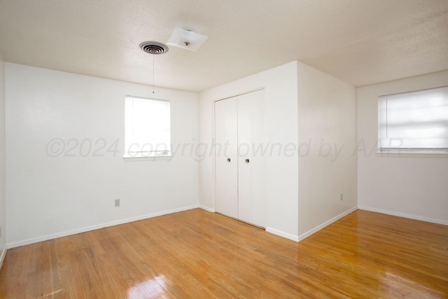 empty room featuring wood-type flooring and a textured ceiling