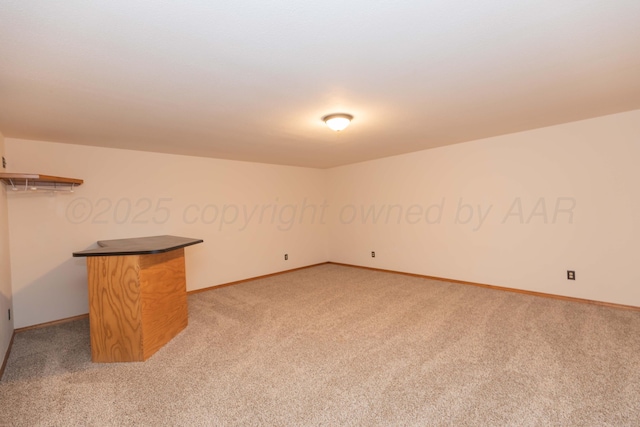 unfurnished room featuring light colored carpet and baseboards