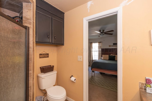 ensuite bathroom featuring ceiling fan, toilet, baseboards, and a shower