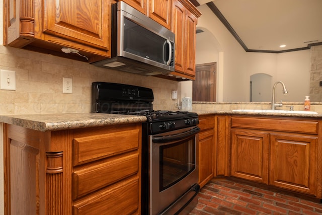 8102 Little Rock Dr, Amarillo, TX 79118 - kitchen with stainless steel appliances, ornamental molding, brown cabinets, brick flooring, and backsplash