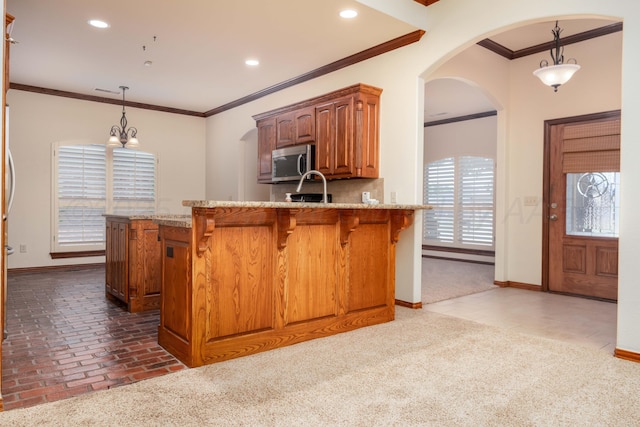 8102 Little Rock Dr, Amarillo, TX 79118 - kitchen featuring stainless steel microwave, crown molding, light stone counters, a kitchen bar, and recessed lighting