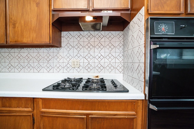 3110 S Apache St, Amarillo, TX 79103 - kitchen with black appliances, range hood, light countertops, tasteful backsplash, and brown cabinets