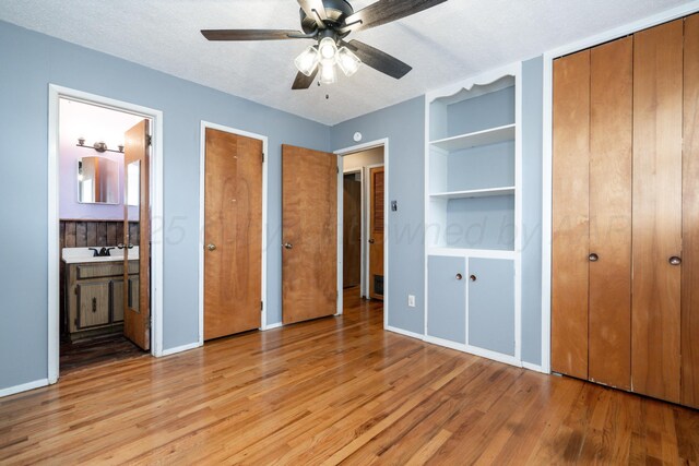3110 S Apache St, Amarillo, TX 79103 - unfurnished bedroom featuring light wood finished floors, multiple closets, ensuite bath, and a textured ceiling
