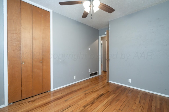3110 S Apache St, Amarillo, TX 79103 - unfurnished bedroom with light wood-style flooring, a textured ceiling, a ceiling fan, and a closet