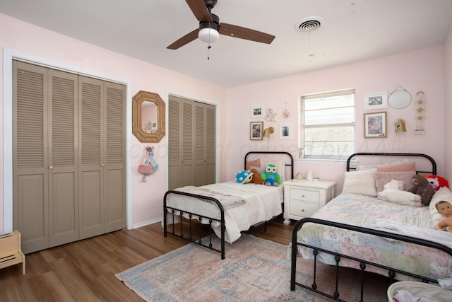 3509 Huntington Dr, Amarillo, TX 79109 - bedroom featuring two closets, wood finished floors, a baseboard heating unit, and a ceiling fan