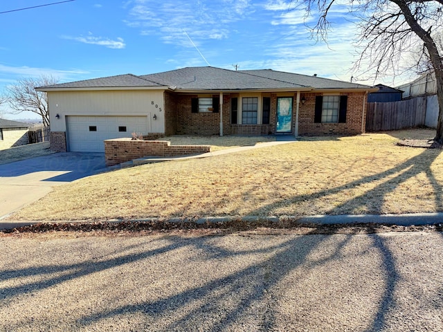 ranch-style home featuring a garage, concrete driveway, brick siding, and fence