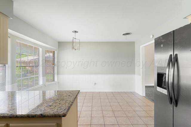 5003 Greenway Pl, Amarillo, TX 79109 - kitchen featuring stainless steel fridge, a wainscoted wall, light tile patterned flooring, pendant lighting, and dark stone countertops