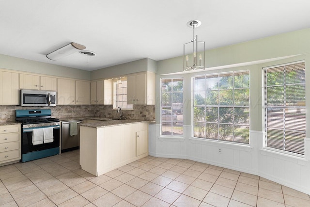 5003 Greenway Pl, Amarillo, TX 79109 - kitchen featuring stainless steel appliances, decorative backsplash, light tile patterned flooring, a peninsula, and decorative light fixtures