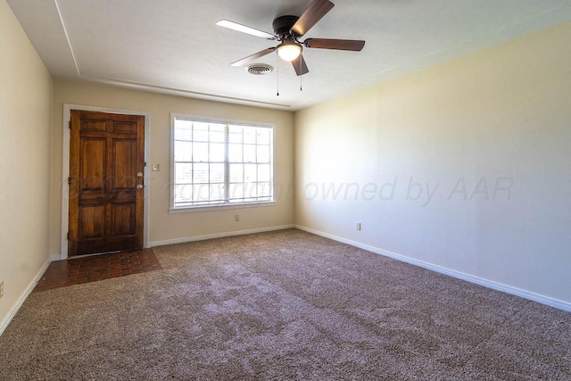 carpeted spare room featuring ceiling fan and baseboards