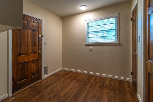entrance foyer with dark wood-style flooring and baseboards