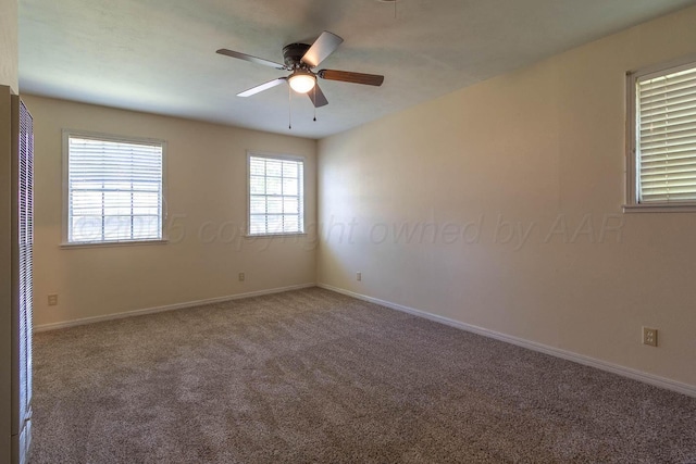 carpeted spare room with a ceiling fan, baseboards, and a heating unit