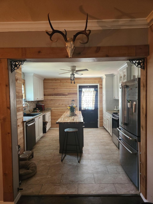 3114 Palm St, Amarillo, TX 79107 - kitchen with appliances with stainless steel finishes, crown molding, white cabinetry, ceiling fan, and a center island