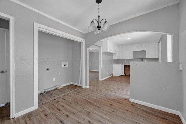 4360 S Polk St, Amarillo, TX 79110 - unfurnished dining area featuring a chandelier, wood finished floors, arched walkways, and crown molding
