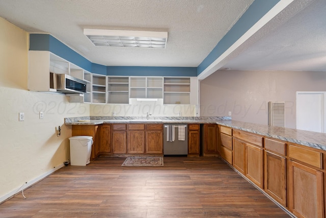 kitchen featuring dark wood-style flooring, open shelves, a textured ceiling, brown cabinetry, and stainless steel appliances