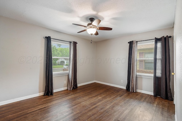 unfurnished room featuring baseboards, a ceiling fan, dark wood finished floors, and a textured ceiling