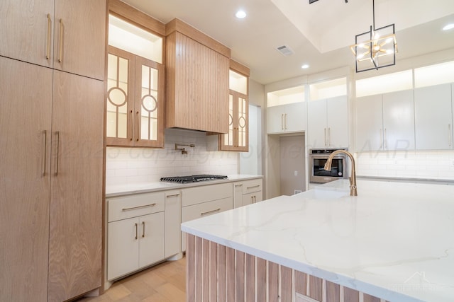 1207 Herring Ranch Rd, Amarillo, TX 79124 - kitchen featuring appliances with stainless steel finishes, tasteful backsplash, glass insert cabinets, light stone counters, and recessed lighting
