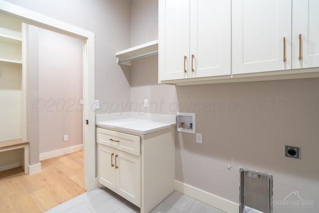 1207 Herring Ranch Rd, Amarillo, TX 79124 - laundry room with electric dryer hookup, hookup for a washing machine, cabinet space, light wood-type flooring, and gas dryer hookup