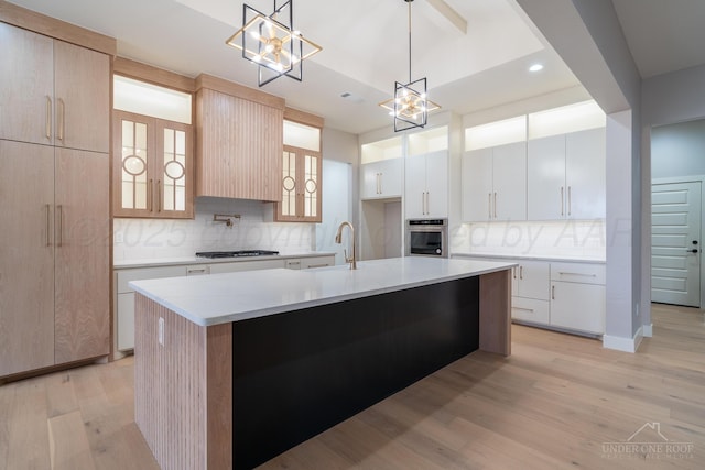 1207 Herring Ranch Rd, Amarillo, TX 79124 - kitchen with a chandelier, light wood-type flooring, decorative backsplash, gas cooktop, and glass insert cabinets